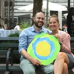 Um casal em um banco com o logotipo da Idealist entre eles.